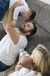 Parents with male newborn and little son having fun at home - OJF00189