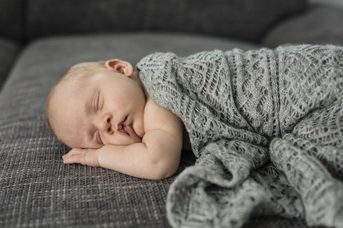 Neugeborenes Baby schläft auf der Couch, lizenzfreies Stockfoto