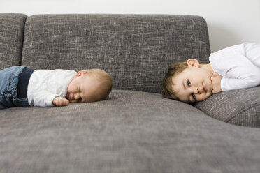 Schlafender neugeborener Junge und sein Bruder auf der Couch - OJF00193