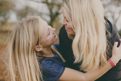 Mother and daughter smiling at each other stock photo