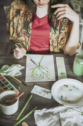 Young woman painting plants with water colors - RTBF00842