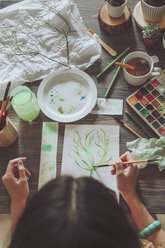 Young woman painting plants with water colors - RTBF00847