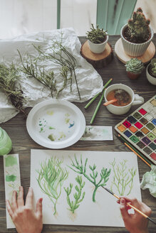 Junge Frau malt Pflanzen mit Wasserfarben - RTBF00855