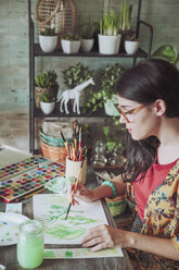 Junge Frau malt Pflanzen mit Wasserfarben - RTBF00857