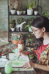 Young woman painting plants with water colors - RTBF00857