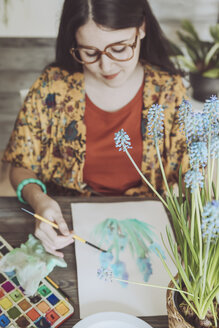 Junge Frau malt Pflanzen mit Wasserfarben - RTBF00867