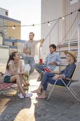 Friends having a rooftop party on a beautiful summer evening - WESTF23072