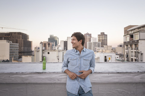 Selbstbewusster junger Mann auf einer Dachterrasse, lizenzfreies Stockfoto