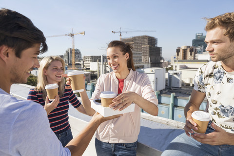 Freunde trinken Kaffee auf einer Dachterrasse, lizenzfreies Stockfoto