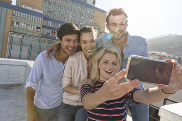 Friends taking selfies on a rooftop terrace - WESTF23101