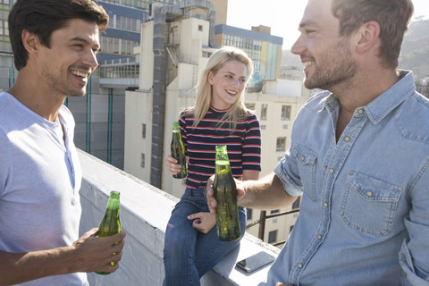 Freunde bei einem Drink auf einer Dachterrasse, lizenzfreies Stockfoto