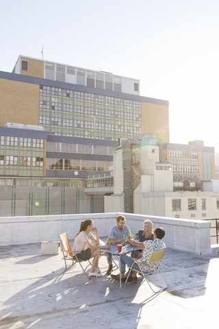 Freunde feiern eine Dachterrassenparty an einem schönen Sommerabend, lizenzfreies Stockfoto