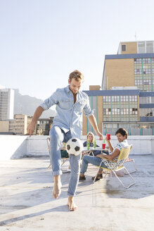 Freunde treffen sich im Sommer auf der Dachterrasse und spielen Fußball - WESTF23121