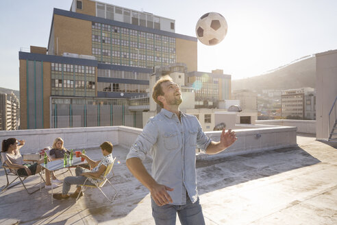 Freunde treffen sich im Sommer auf der Dachterrasse und spielen Fußball - WESTF23122