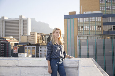 Junge Frau steht auf einer Dachterrasse - WESTF23127