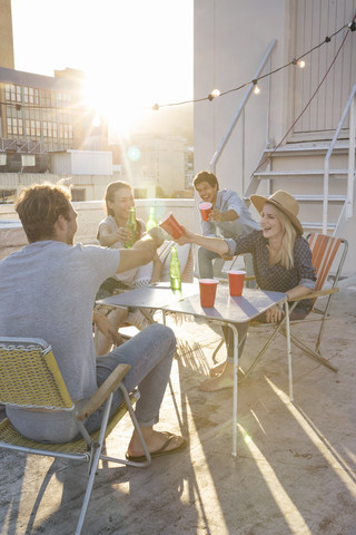 Freunde feiern eine Dachterrassenparty an einem schönen Sommerabend, lizenzfreies Stockfoto