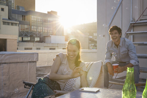 Freunde feiern eine Dachterrassenparty an einem schönen Sommerabend - WESTF23132