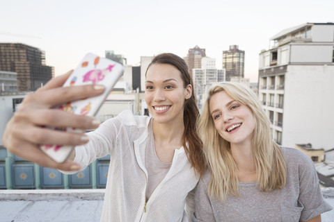 Freunde machen Selfies auf einer Dachterrasse, lizenzfreies Stockfoto