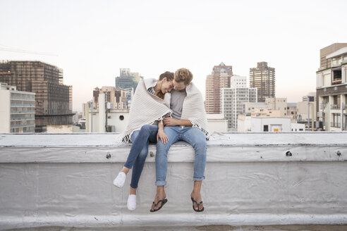 Romantisches Paar sitzt auf der Dachterrasse und genießt die Aussicht - WESTF23149