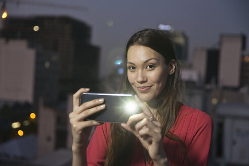 Junge Frau fotografiert ihre Freunde auf einer Dachterrassenparty - WESTF23157