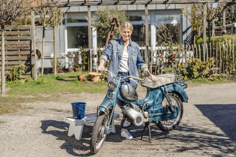 Lächelnde Frau mit Oldtimer-Motorrad, lizenzfreies Stockfoto