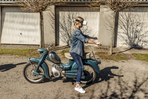 Frau mit Oldtimer-Motorrad und VR-Brille - JOSF00773