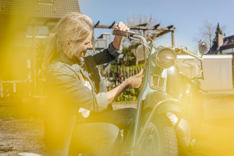 Lächelnde Frau mit Oldtimer-Motorrad, lizenzfreies Stockfoto