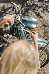 Woman repairing vintage motorcycle - JOSF00777