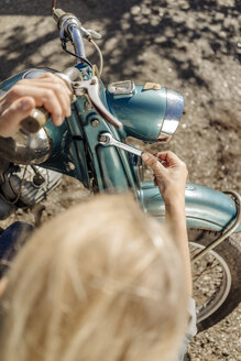 Frau repariert altes Motorrad - JOSF00777