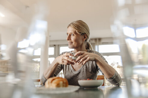 Frau zu Hause am Tisch sitzend beim Frühstück - JOSF00790