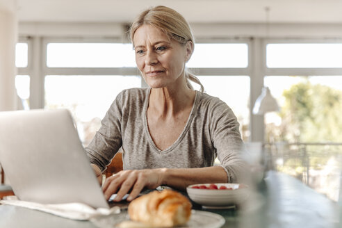 Frau zu Hause beim Frühstück und mit Laptop - JOSF00792