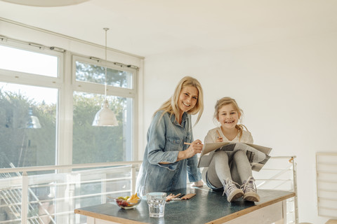 Mature woman and girl at home drawing together stock photo