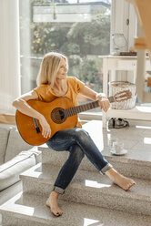 Smiling woman at home with guitar - JOSF00829