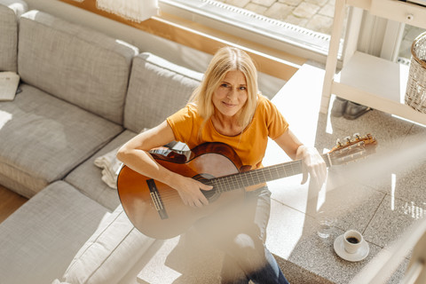 Frau zu Hause spielt Gitarre, lizenzfreies Stockfoto