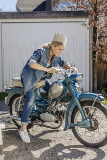 Glückliche Frau auf einem alten Motorrad mit Krone - JOSF00901