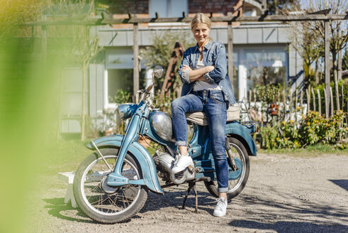 Lächelnde Frau mit Oldtimer-Motorrad - JOSF00905