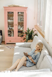 Frau zu Hause auf der Couch mit Tablet - JOSF00922