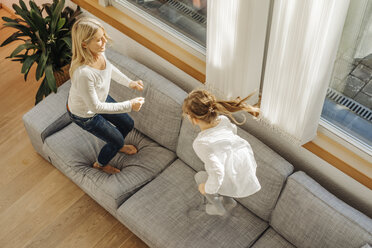 Reife Frau und Mädchen zu Hause hüpfen auf Couch - JOSF00938