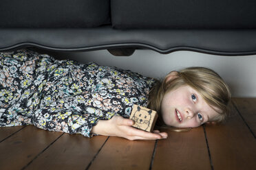 Mädchen liegt auf dem Boden und hält eine Schachtel mit einer bemalten Maus - PSTF00006