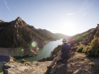 Spanien, Sierra de Gueejar, Rückenansicht eines Wanderers mit Blick auf den Fluss Genil bei Abendsonne - LAF01841