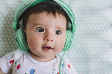 Porträt eines begeisterten kleinen Mädchens mit Kopfhörern - GEMF01608
