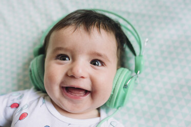 Porträt eines lachenden kleinen Mädchens mit Kopfhörern - GEMF01611