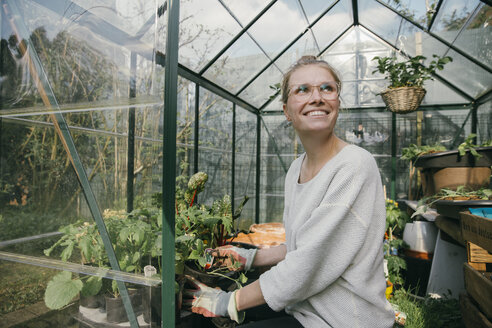Portrait of happy young woman in her greenhouse - MFF03487