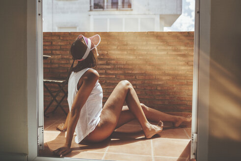 Frau beim Sonnenbad auf einem Balkon - KIJF01485