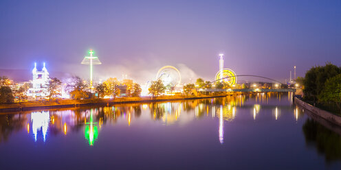 Germany, Stuttgart, lighted Cannstatter Wasen fairground with Neckar River in the foreground - WDF04013