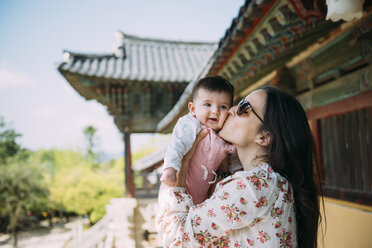South Korea, Gyeongju, womankissing a baby girl in Bulguksa Temple - GEMF01619