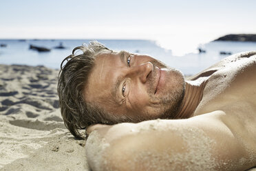 Portrait of man relaxing on sandy beach - PDF01229