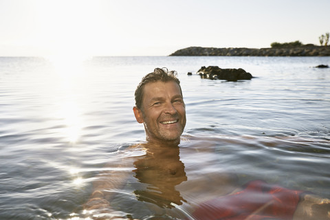 Portrait of smiling man bathing in the sea stock photo