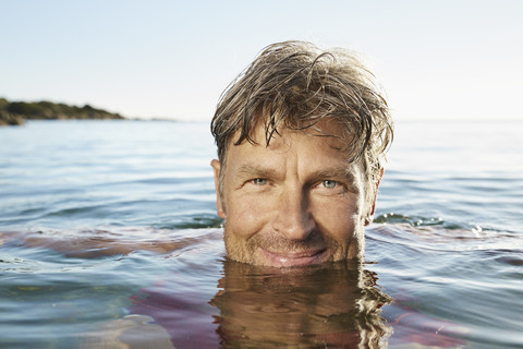 Porträt eines lächelnden Mannes beim Baden im Meer, lizenzfreies Stockfoto