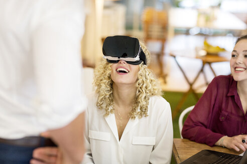 Blonde Frau probiert VR-Brille in einem Workshop aus - PESF00561